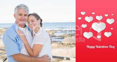 Composite image of happy casual couple embracing by the sea