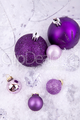 beautiful christmas decoration in purple and silver on white snow