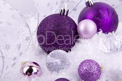 beautiful christmas decoration in purple and silver on white snow