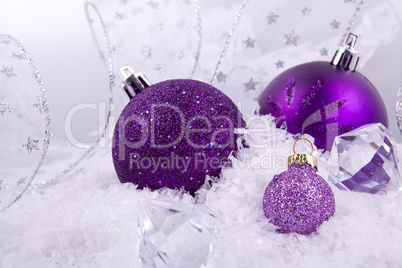 beautiful christmas decoration in purple and silver on white snow