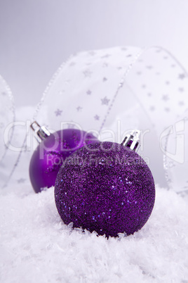 beautiful christmas decoration in purple and silver on white snow