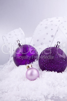 beautiful christmas decoration in purple and silver on white snow