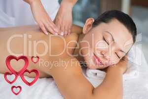 Composite image of content brunette getting a back massage