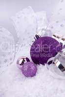 beautiful christmas decoration in purple and silver on white snow