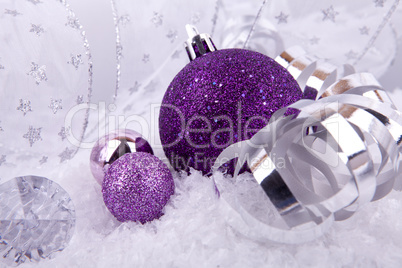 beautiful christmas decoration in purple and silver on white snow