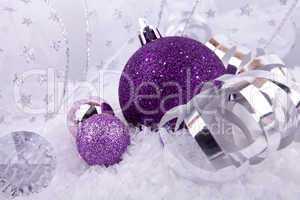 beautiful christmas decoration in purple and silver on white snow