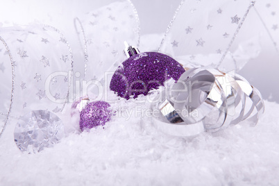 beautiful christmas decoration in purple and silver on white snow