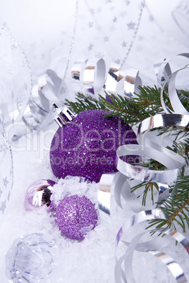 beautiful christmas decoration in purple and silver on white snow