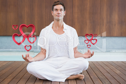 Composite image of handsome man in white meditating in lotus pos