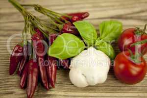 red hot chilli pepper with basil and garlic on table