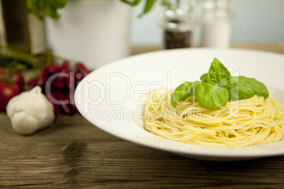 tasty fresh pasta with garlic and basil on table