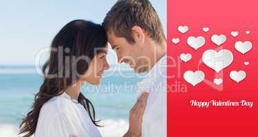 Composite image of attractive couple embracing on the beach