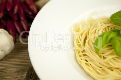 tasty fresh pasta with garlic and basil on table