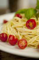 fresh tasty pasta with tomato and basil on table
