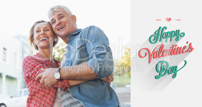 Composite image of happy mature couple hugging in the city