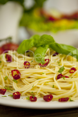 fresh pasta with basil and red chilli on table