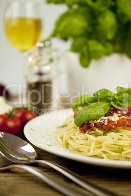 fresh pasta with tomato sauce and basil on wooden table