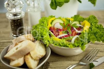 fresh tasty healthy mixed salad and bread on table