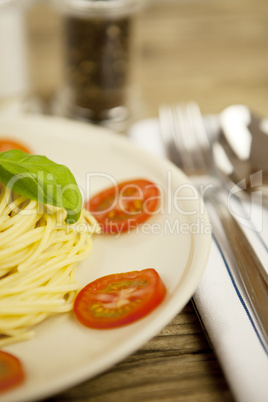 fresh tasty pasta with tomato and basil on table