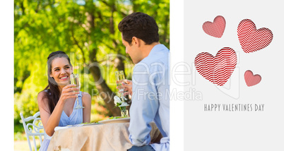 Composite image of couple toasting champagne flutes at an outdoo