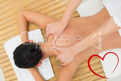 Composite image of peaceful brunette enjoying a shoulder massage