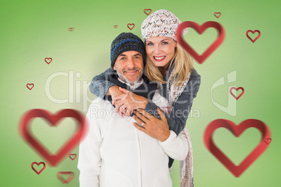 Composite image of happy couple in winter fashion embracing