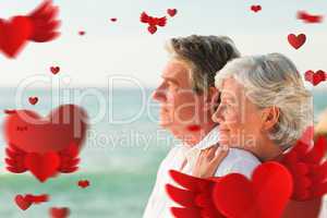 Composite image of woman hugging her husband at the beach