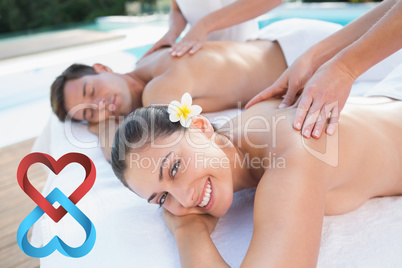 Composite image of attractive couple enjoying couples massage po