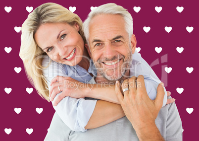 Composite image of happy couple standing and hugging