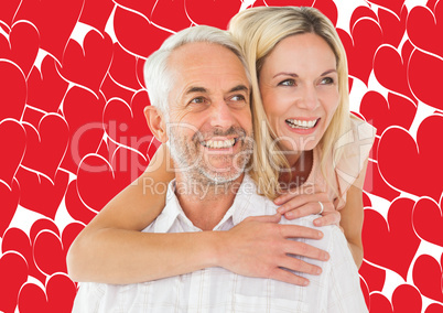 Composite image of happy man giving his partner a piggy back