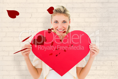 Composite image of attractive young blonde showing red heart