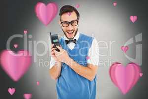 Composite image of geeky hipster holding a retro cellphone