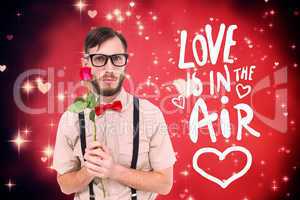 Composite image of geeky hipster offering a rose