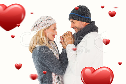 Composite image of couple in winter fashion embracing