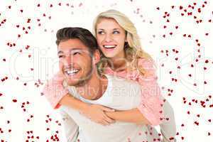 Composite image of handsome man giving piggy back to his girlfri