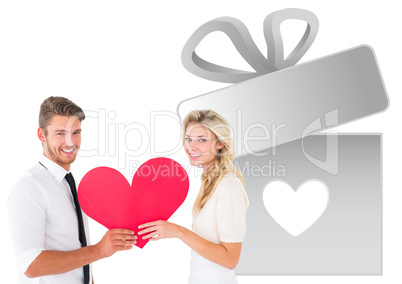 Composite image of attractive young couple holding red heart