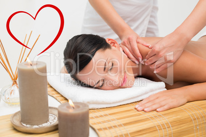 Composite image of beautiful brunette enjoying a shoulder massag