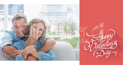Composite image of content man hugging his wife on the couch