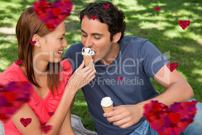 Composite image of woman feeding her friend ice cream
