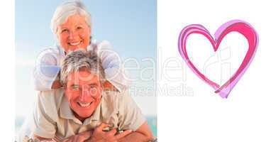 Composite image of senior couple lying down on the beach