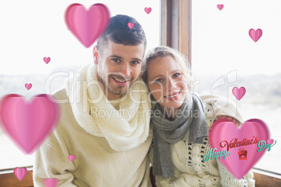 Composite image of couple in winter clothing sitting against win