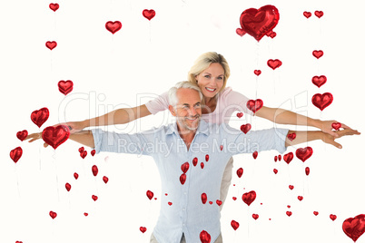 Composite image of smiling couple posing with arms out