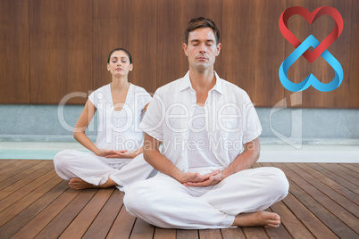 Composite image of peaceful couple in white sitting in lotus pos