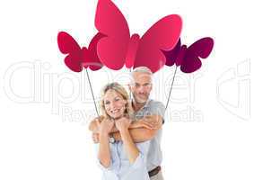 Composite image of happy couple standing and hugging