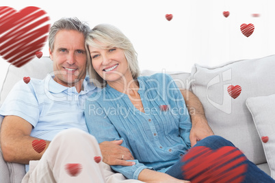 Composite image of cheerful couple on their couch