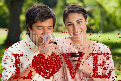 Composite image of woman smiling while her friend is drinking wi