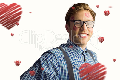 Composite image of geeky hipster covered in kisses