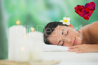 Composite image of beautiful brunette relaxing on massage table