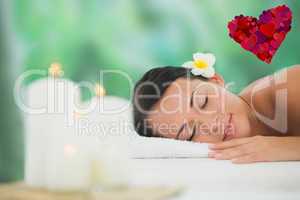 Composite image of beautiful brunette relaxing on massage table