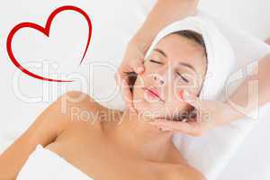 Composite image of attractive woman receiving facial massage at